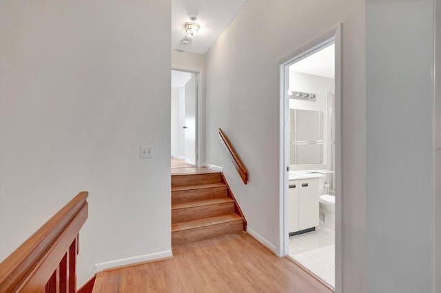 stairs featuring wood finished floors and baseboards