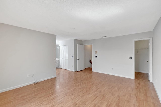 empty room featuring baseboards and light wood finished floors