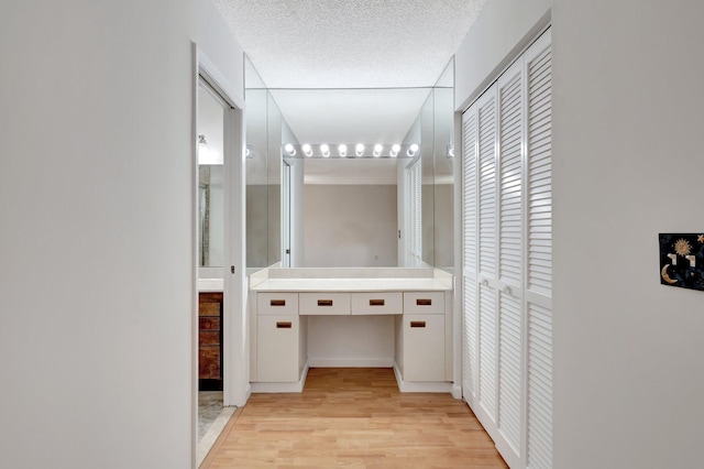 hall featuring a textured ceiling and light wood-type flooring