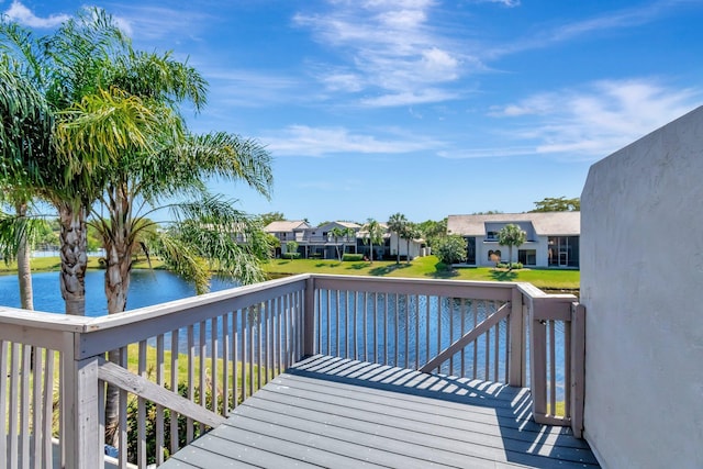 wooden deck with a residential view and a water view