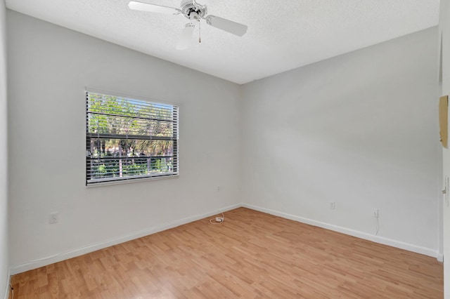 unfurnished room with light wood-style flooring, baseboards, and a textured ceiling