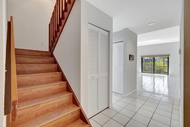 stairs featuring tile patterned flooring and baseboards