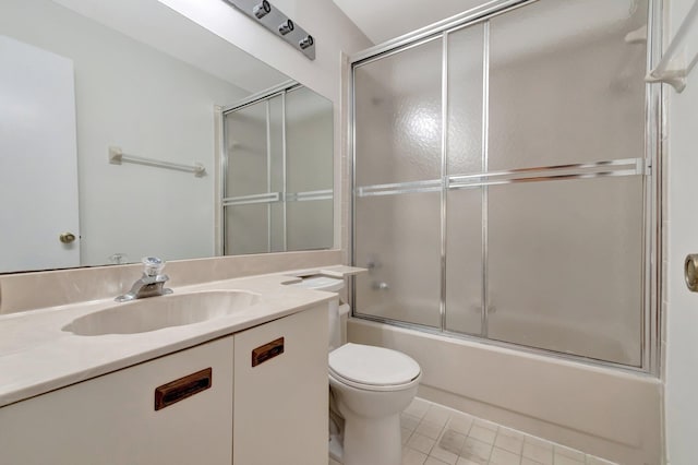 full bath featuring tile patterned floors, toilet, vanity, and bath / shower combo with glass door