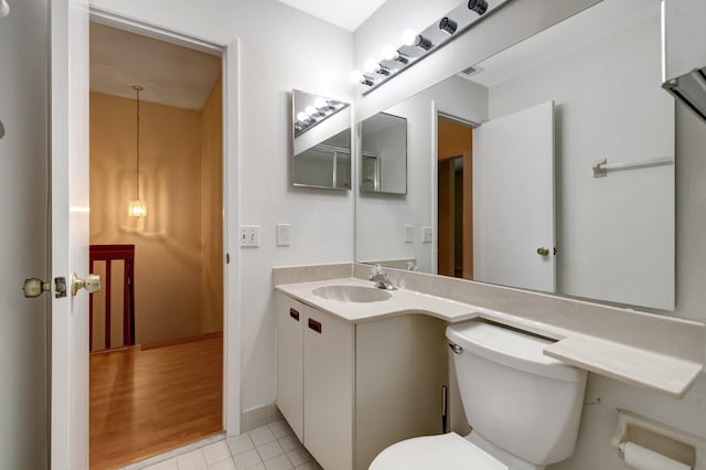 bathroom featuring vanity, baseboards, visible vents, tile patterned flooring, and toilet