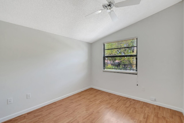 spare room with light wood-style flooring, a ceiling fan, a textured ceiling, baseboards, and vaulted ceiling