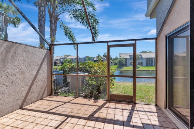 unfurnished sunroom with a water view