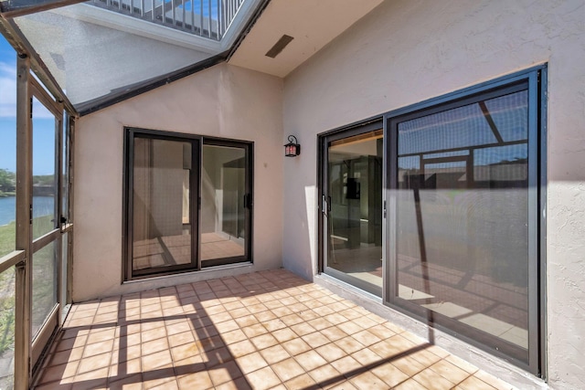 unfurnished sunroom featuring lofted ceiling and a water view