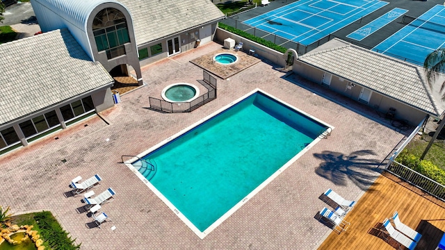 pool featuring a patio, fence, and a hot tub