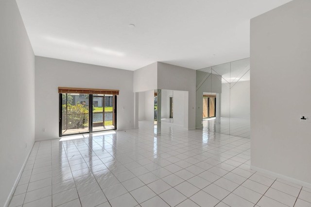 unfurnished room featuring light tile patterned floors and baseboards