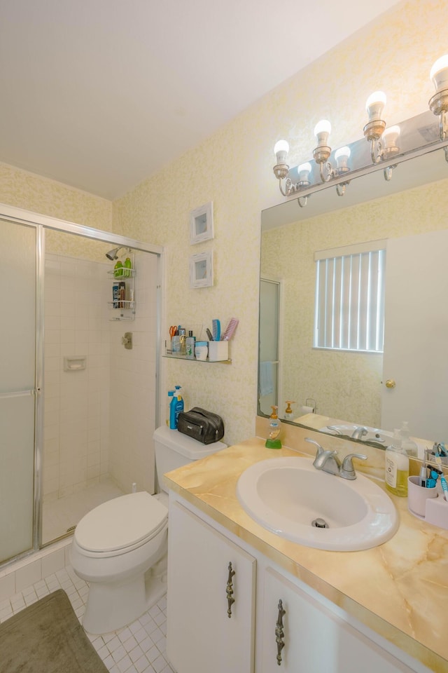 bathroom featuring toilet, a stall shower, tile patterned flooring, wallpapered walls, and vanity