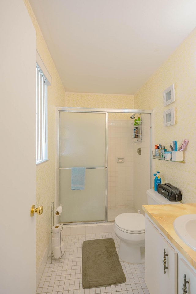 bathroom featuring tile patterned floors, toilet, a stall shower, wallpapered walls, and vanity