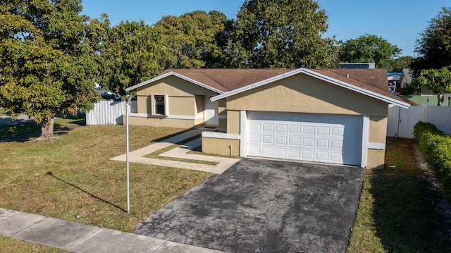 ranch-style home featuring stucco siding, aphalt driveway, fence, an attached garage, and a front yard