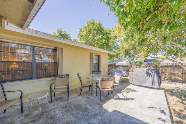 view of patio featuring outdoor dining space and fence