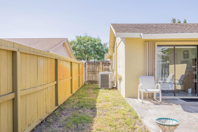 view of yard with a patio, central AC, and fence