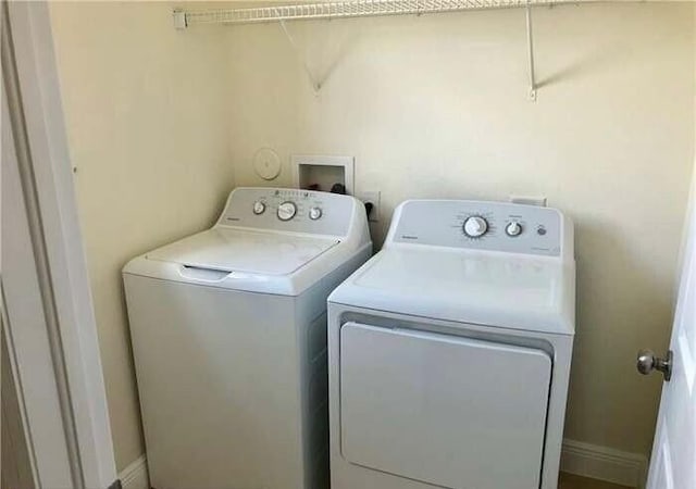 clothes washing area featuring baseboards, independent washer and dryer, and laundry area