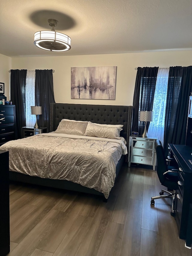 bedroom with multiple windows and wood finished floors