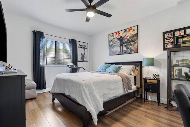 bedroom with baseboards, wood finished floors, and a ceiling fan