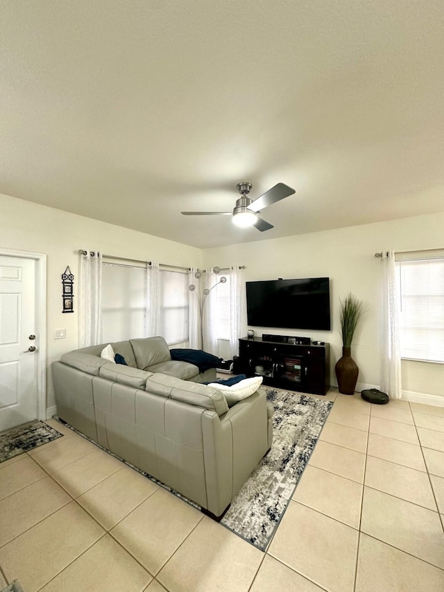 tiled living room with baseboards and ceiling fan