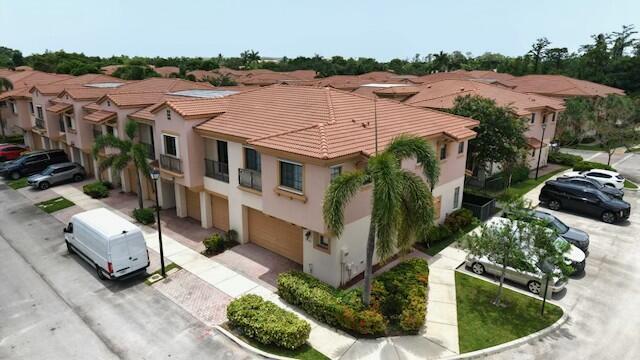 4780 Grand Cypress Cir N, Coconut Creek, FL 33073 - view of building exterior featuring a garage, driveway, and a residential view