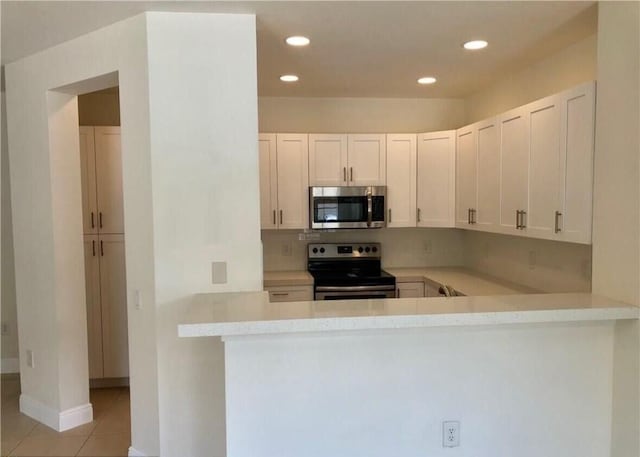 kitchen with tasteful backsplash, light countertops, recessed lighting, appliances with stainless steel finishes, and light tile patterned flooring