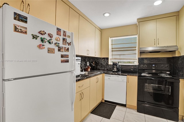 kitchen with white appliances, cream cabinets, tasteful backsplash, and under cabinet range hood