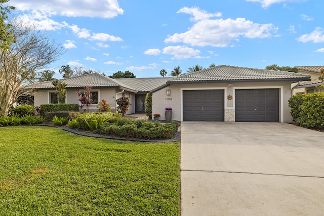 single story home featuring a tiled roof, a front yard, stucco siding, a garage, and driveway