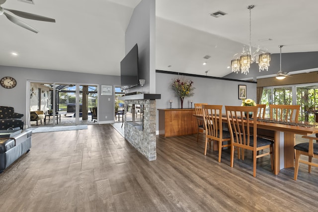 dining room featuring wood finished floors, a fireplace, visible vents, and a healthy amount of sunlight