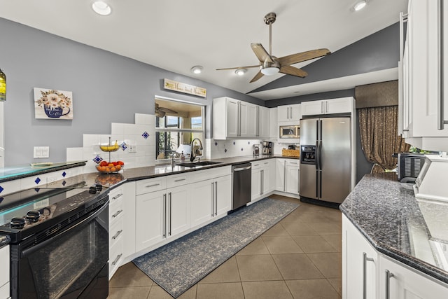 kitchen featuring a sink, stainless steel appliances, dark tile patterned floors, and white cabinetry