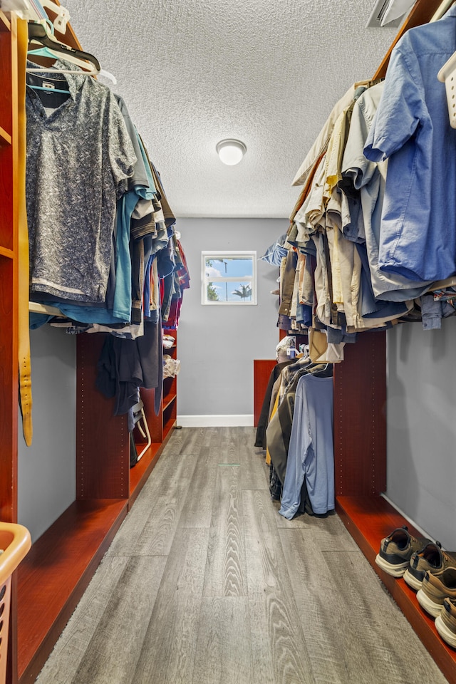 walk in closet with wood finished floors and visible vents