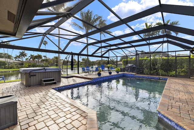 outdoor pool with glass enclosure, a patio area, and a hot tub