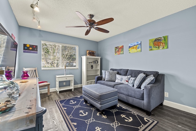 living area featuring ceiling fan, wood finished floors, baseboards, and a textured ceiling