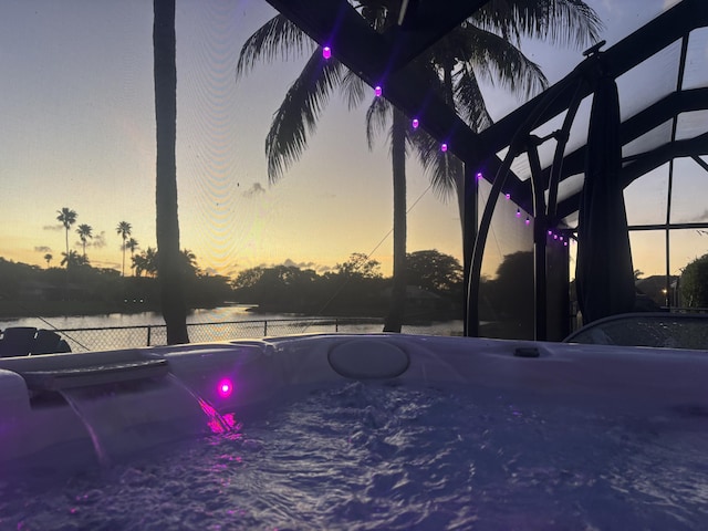 view of swimming pool with a lanai and fence