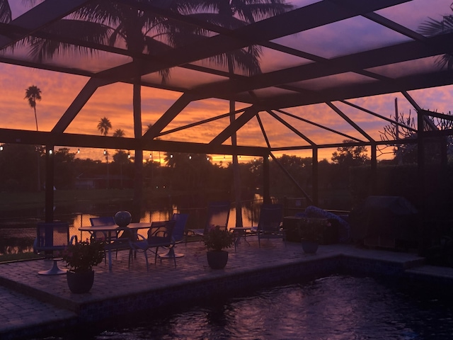 view of pool featuring glass enclosure and a patio