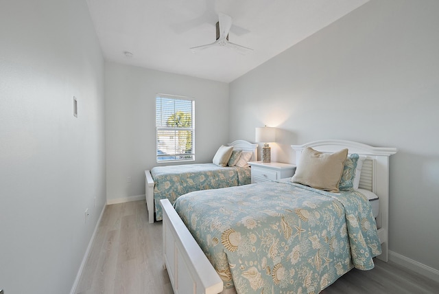 bedroom featuring light wood-style flooring, baseboards, and ceiling fan