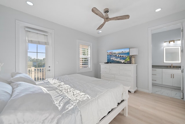 bedroom with access to exterior, light wood-type flooring, recessed lighting, ensuite bathroom, and a sink