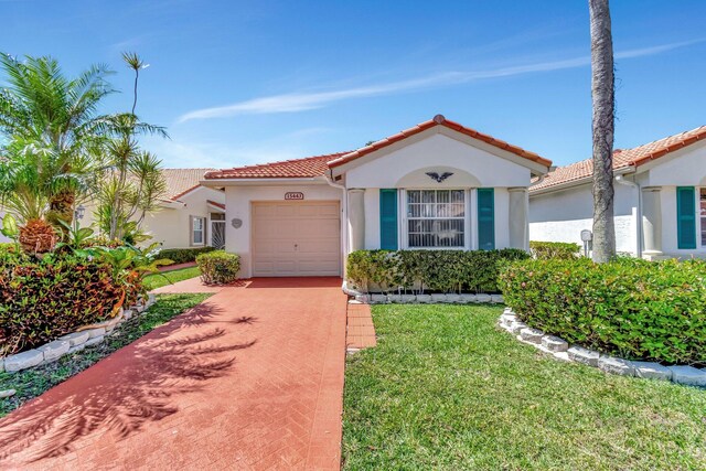 15443 Floral Club Rd, Delray Beach, FL 33484 - mediterranean / spanish house with stucco siding, concrete driveway, a front lawn, a garage, and a tile roof