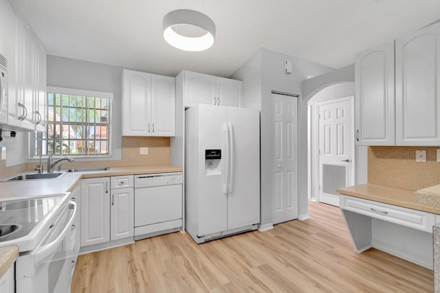 15443 Floral Club Rd, Delray Beach, FL 33484 - kitchen featuring light countertops, light wood-type flooring, decorative backsplash, white cabinets, and white appliances