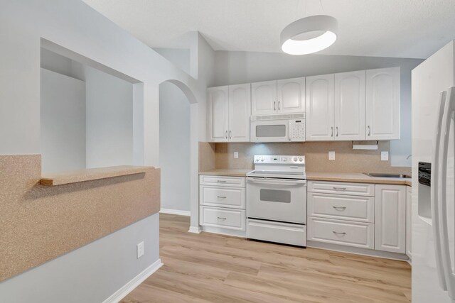15443 Floral Club Rd, Delray Beach, FL 33484 - kitchen with white cabinets, white appliances, light countertops, and light wood-style floors