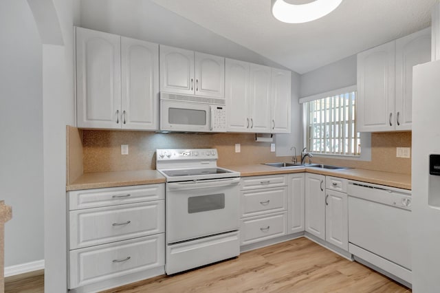 15443 Floral Club Rd, Delray Beach, FL 33484 - kitchen with white appliances, white cabinets, light wood finished floors, and a sink