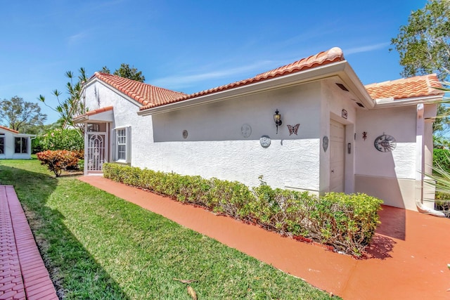 15443 Floral Club Rd, Delray Beach, FL 33484 - view of side of home with a tile roof, a yard, and stucco siding