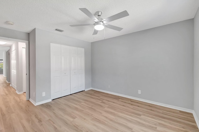 15443 Floral Club Rd, Delray Beach, FL 33484 - unfurnished bedroom with light wood-type flooring, visible vents, a textured ceiling, a closet, and baseboards