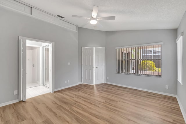 15443 Floral Club Rd, Delray Beach, FL 33484 - unfurnished bedroom featuring baseboards, lofted ceiling, light wood-style floors, and a textured ceiling