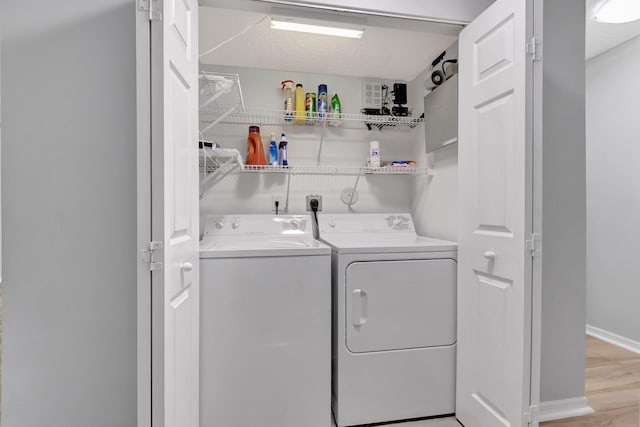 15443 Floral Club Rd, Delray Beach, FL 33484 - laundry room with laundry area, baseboards, light wood finished floors, and washing machine and clothes dryer