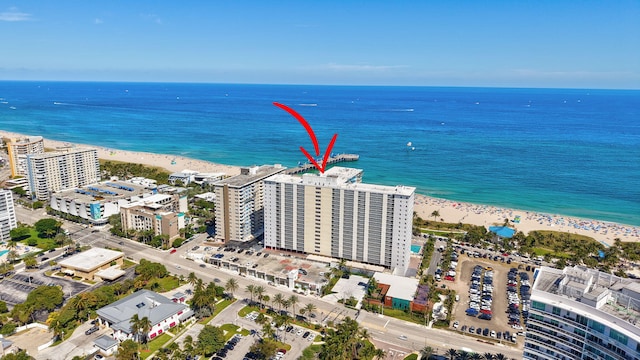 aerial view featuring a city view, a view of the beach, and a water view