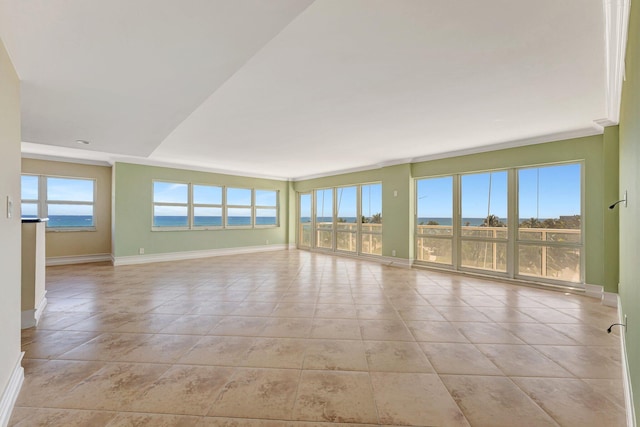 spare room with crown molding, light tile patterned floors, and baseboards