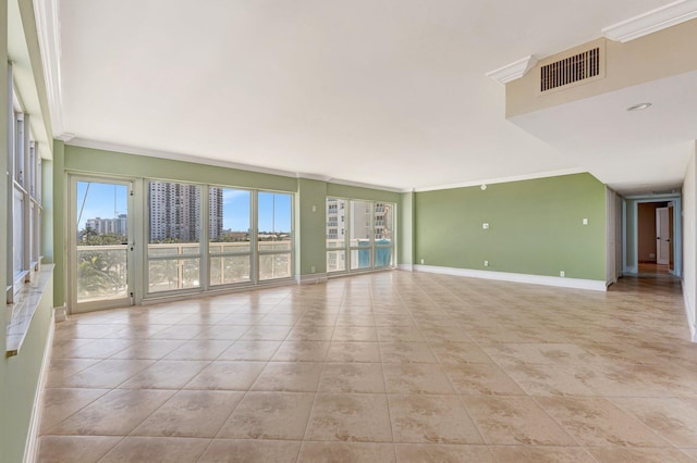 spare room with light tile patterned floors, visible vents, crown molding, and baseboards