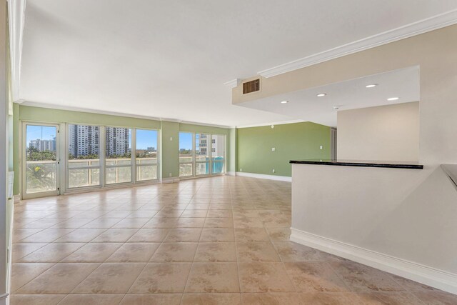 unfurnished room featuring crown molding, light tile patterned flooring, baseboards, and visible vents