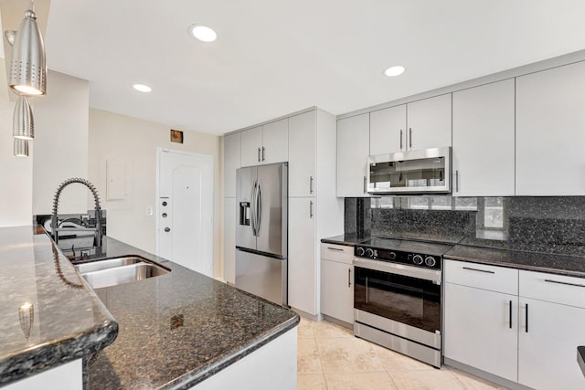 kitchen with backsplash, dark stone countertops, recessed lighting, stainless steel appliances, and a sink