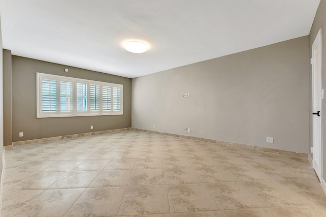 unfurnished room featuring light tile patterned floors and baseboards