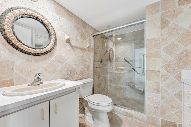 bathroom featuring tile patterned flooring, vanity, a shower stall, and toilet